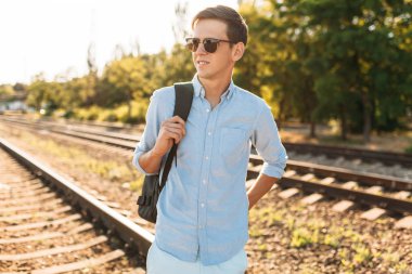 Gün batımı, yenilikçi şık giysiler içinde poz, tren rayları üzerinde poz güzel şık gözlüklü,,