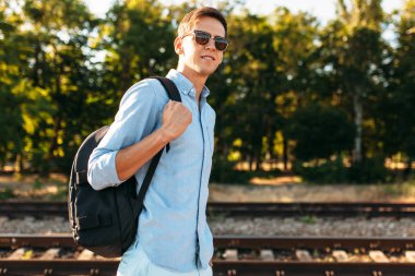 Gün batımı, yenilikçi şık giysiler içinde poz, tren rayları üzerinde poz güzel şık gözlüklü,,