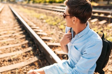 Gün batımı, yenilikçi şık giysiler içinde poz, tren rayları üzerinde oturan poz güzel şık gözlüklü,,