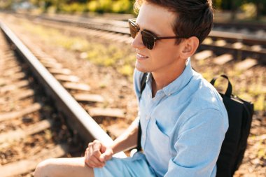 Gün batımı, yenilikçi şık giysiler içinde poz, tren rayları üzerinde oturan poz güzel şık gözlüklü,,