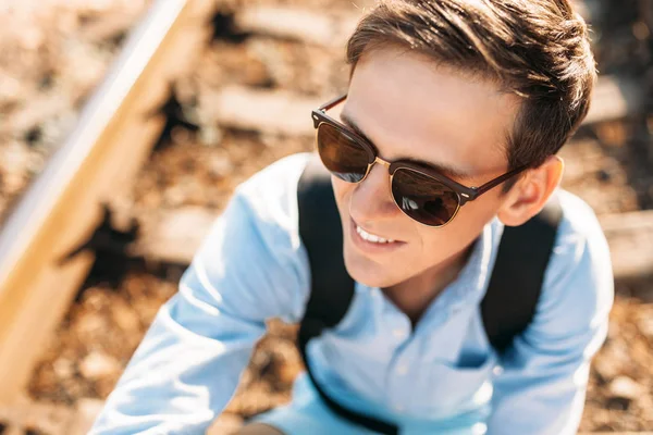 Gün batımı, yenilikçi şık giysiler içinde poz, tren rayları üzerinde oturan poz güzel şık gözlüklü,,