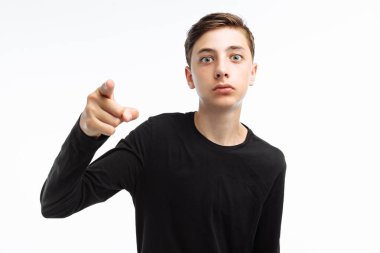 Güzel bir genç, sürpriz bir göz olan bir adam portresi ellerini kamerada beyaz bir arka plan üzerinde siyah bir tişört işaret eden,