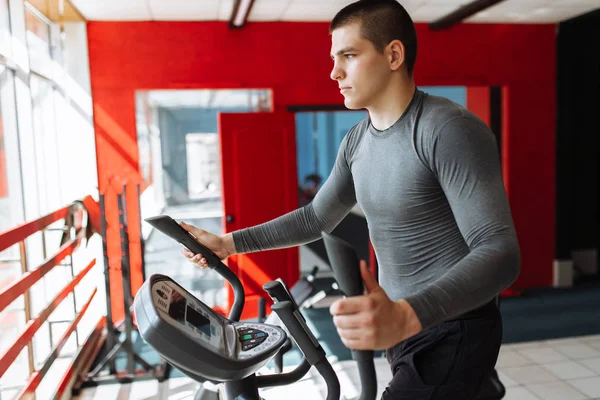 spor salonunda spor bisikletle eğitim yapan bir adam