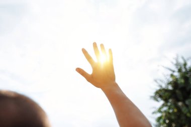 yardım için gökyüzüne ulaşır ve güneş kapakları, Güneş ışınları yakın el - yukarıya onların yol yapmak