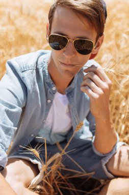 Bir buğday alanı, gözlüklü bir adam ve bir kap içinde bir adam portresi