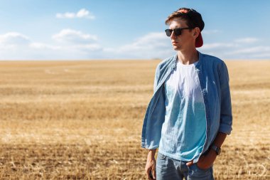 Bir buğday alanı, gözlüklü bir adam ve bir kap içinde bir adam portresi