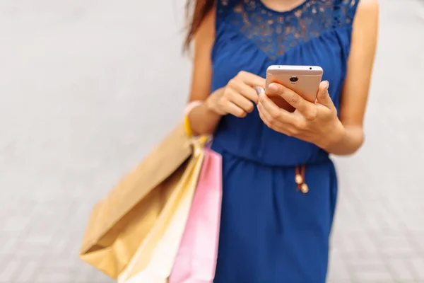 Woman with phone and shopping in hand, shopping online