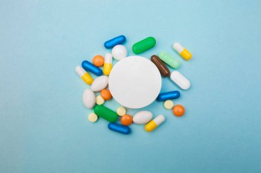 Çok renkli tablet ve kapsül, tablet, ilaç tıp hapları üzerinde mavi arka plan, analjezik hastalıklara karşı beyaz şişe