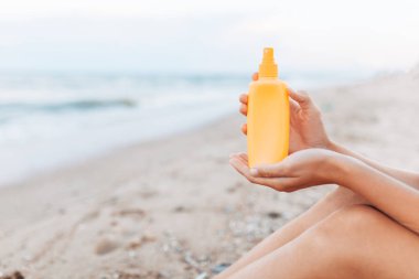 Güzel kız, plaj, ayak yakın çekim, Güneş kremi kavanoz güneş krem uygulama