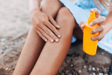 Güzel kız, plaj, ayak yakın çekim, Güneş kremi kavanoz güneş krem uygulama