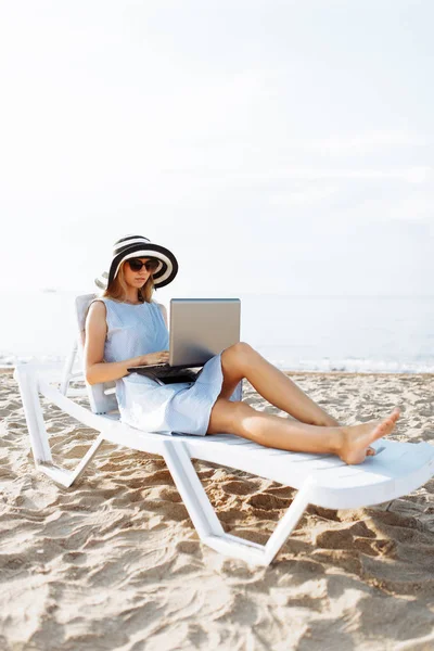 Freelancer girl working on vacation, in front of the beautiful sea