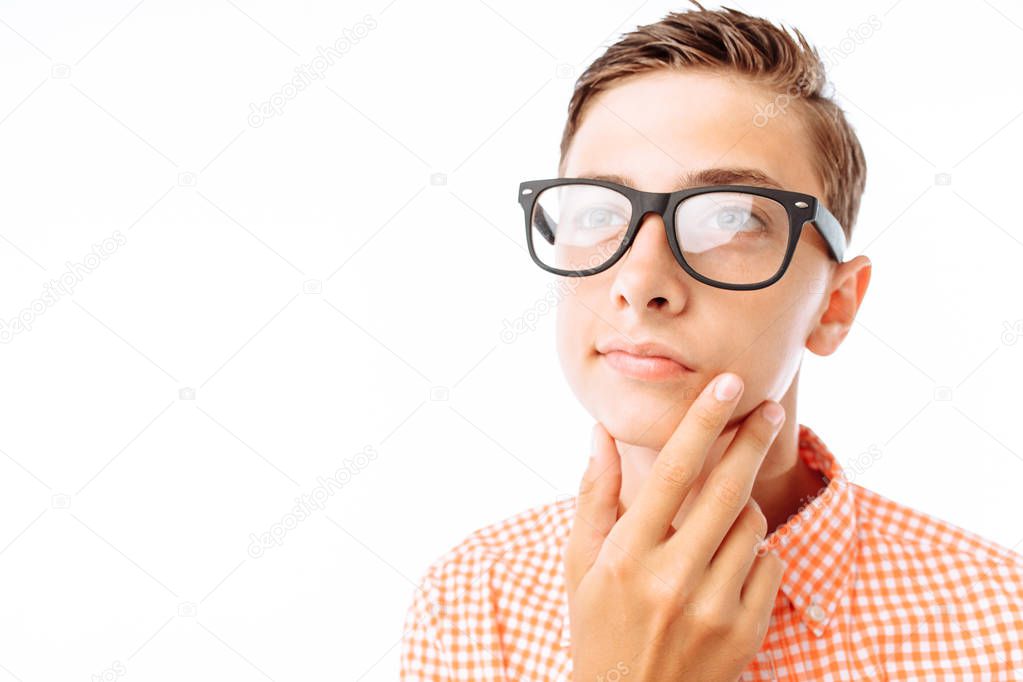 Young man with thoughtful look, guy holding hand near face, boy with glasses in Studio on white background