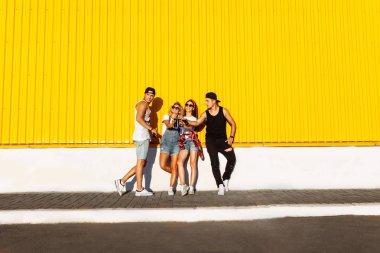 bir içki ile cam şişe ile gençlerin bir grup çekilin süpermarket, sarı bir arka plan üzerinde yakın arkadaş gel dolu, neşeli ruh hali, güneşli bir gün, Lifestyl kavramı, catch anlar birlikte arkadaşlarım ile