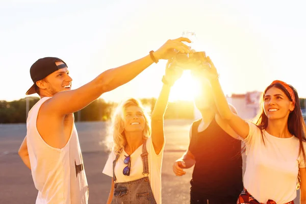 a group of young people with glass bottles with a drink stand near the supermarket, on a yellow background, friends come off in full, cheerful mood, Sunny day, Lifestyl concept, catch moments together with best friends