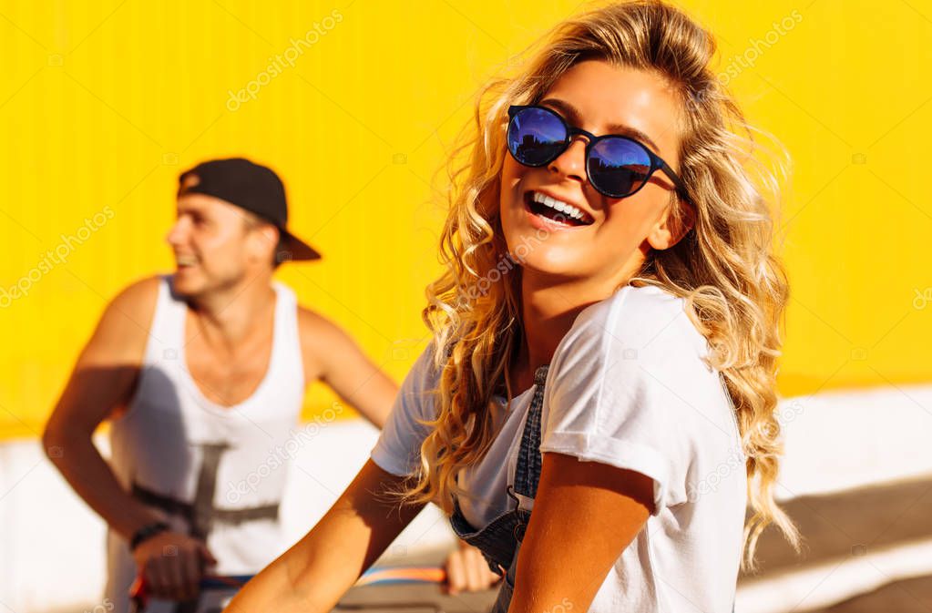Portrait of a close - up of a beautiful girl sitting on a cart, near a supermarket, a great pastime, a group of young people rides on carts, couples in love have fun in Sunny weather
