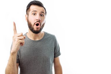 Kişinin duygusal resim coşku, fikri olan beyaz bir arka plan üzerinde ayakta gösterir. Jest kavramı. Gri bir t-shirt bir yakışıklı sakallı adam sadece harika bir fikir geldi ve başkalarıyla paylaşmak istiyor.