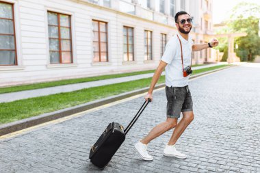 Bir sakallı bir bavul ve sokaklarda, geri kalanı doğru çalışan bir kamera ile pozitif turizm