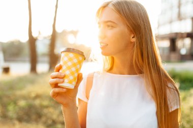 Genç güzel kız içme kahve şehir sırt çantası beyaz tişört, şehirde dolaşan,