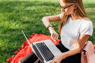 Laptop İnşaat ve açık havada olmak parkta saat, bakarak geç bir güzel kız öğrenci ile gözlük, görüntü