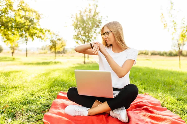 Piękna Dziewczyna Student Okularach Siedzi Parku Laptopa Patrząc Czas Zegarze — Zdjęcie stockowe