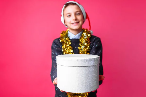 Підліток Санта Hat Мішура Шиї Дає Різдвяний Подарунок Червоному Тлі — стокове фото