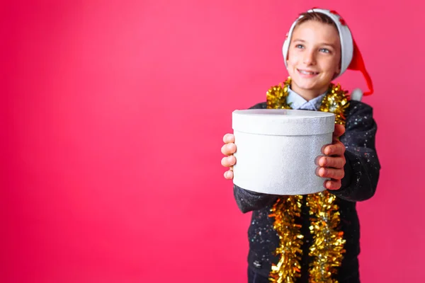Підліток Санта Hat Мішура Шиї Дає Різдвяний Подарунок Червоному Тлі — стокове фото