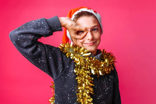 Pozitivní Teen Santa Claus Klobouku Pozlátko Krku Ukazuje Znamení Červeném — Stock fotografie