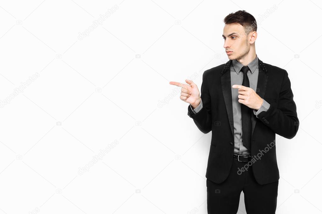 Portrait of an authoritative masculine man, confident, pointing to an empty copy of the space isolated on a white background