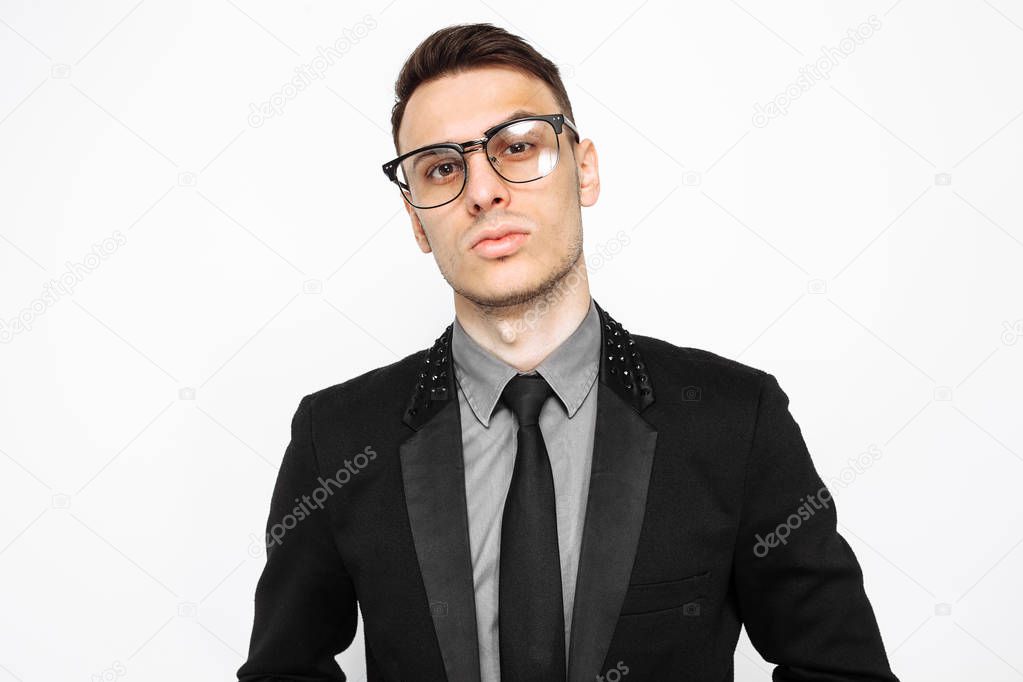 Portrait of a successful man in glasses and a black suit, a businessman posing on a white background