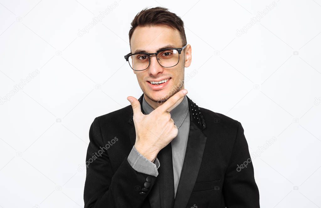 Portrait of an authoritative male man in glasses and suit, confident, pointing to an empty copy of the space isolated on a white background