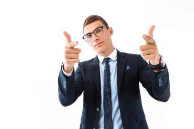 Neşeyle gülümseyen, kameraya parmakları işaret, dikkatini çekmeye çalışırken başarılı iş adamı gözlük ve takım elbise,.