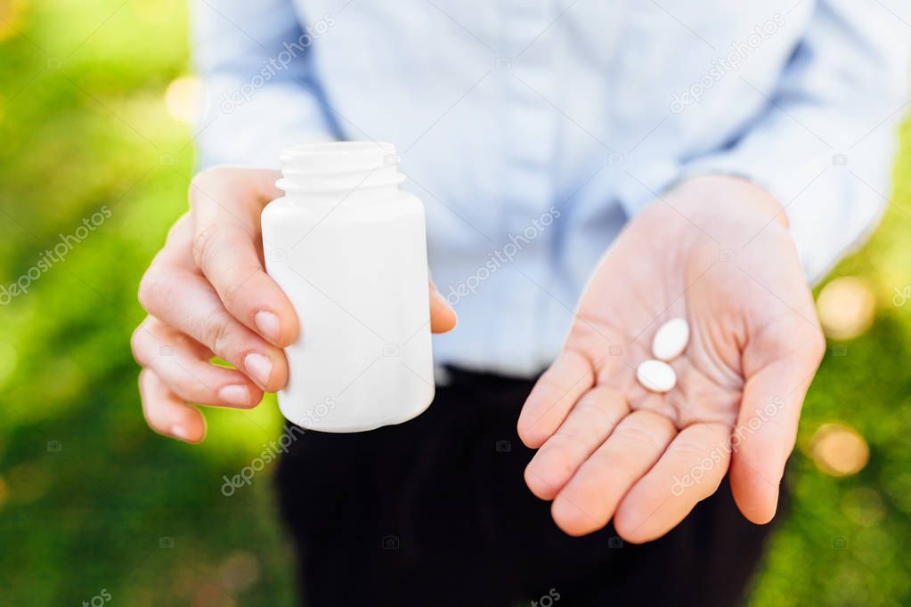 hands holding a jar with pills, closeup