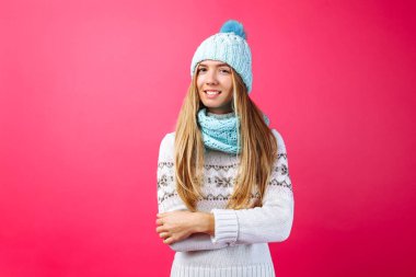 Üzerinde izole kırmızı arka plan, sıcak Mavi şapka ve sıcak eşarp güzel kız ayakta. Kavramı, kış, soğuk, sıcak giysiler