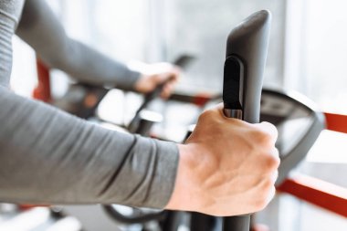 Spor, motor, kolu tutan el yakın çekim spor bisikletle adam eğitim