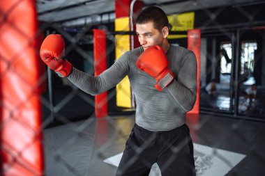 Savaşmadan kuralları için bir kafes içinde spor eğitim yapan erkek boxer