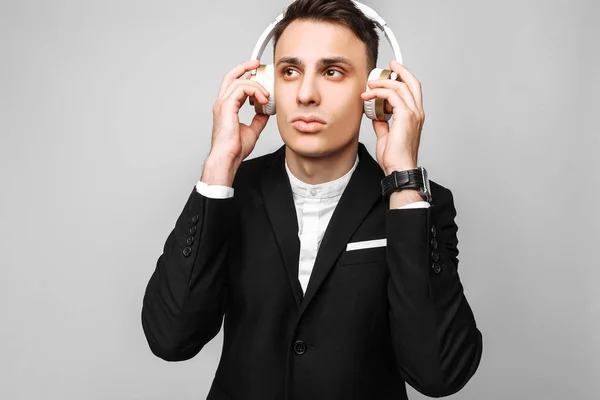 Dinleme Müzik Gri Bir Arka Plan Üzerinde Stüdyoda Kablosuz Kulaklık — Stok fotoğraf