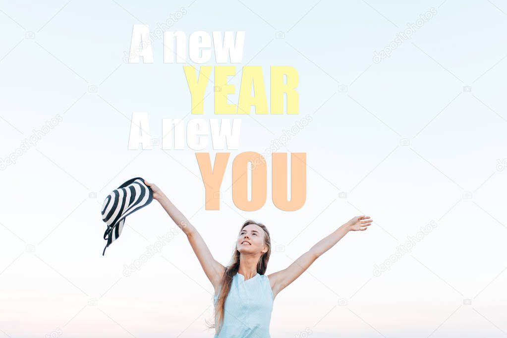 The girl is resting in the fresh air, against the blue sky, feeling free. Image with text. New year new me. christmas concept