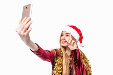 Santa şapka ve kıyafet, mutlu kadın kendini, smartphone vuruyor. beyaz bir arka plan üzerinde