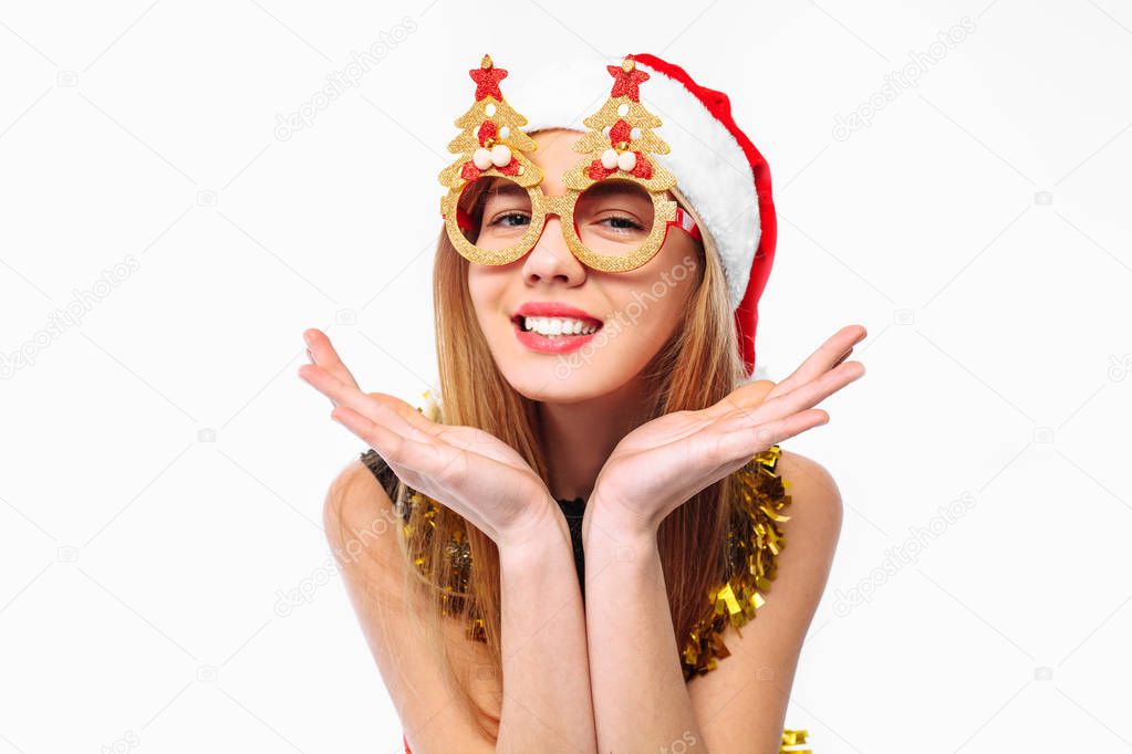 Cheerful woman in santa hat and christmas glasses celebrating new year with tinsel around neck. on a white background