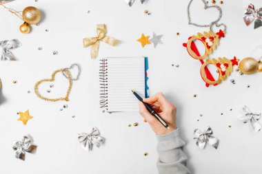 Üstten görünüm kadınların bir defter, Noel dekorasyon Noel ve yeni yıl için bir liste yapmaya bir gol yazma. Beyaz bir arka plan üzerinde