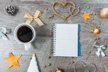 Noel dekorasyonu ile açık bir defter ve bir fincan kahve, yeni yıl planlama. ahşap arka plan üzerinde.