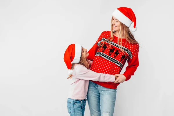 Mãe Filha Estão Usando Chapéus Papai Noel Camisolas Natal Abraçam — Fotografia de Stock