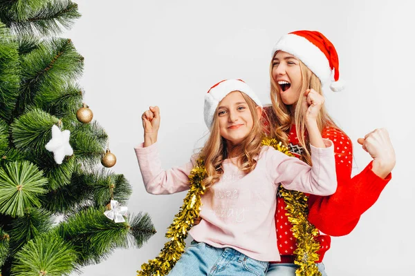 Happy Mom Daughter Santa Hats Sitting Christmas Tree Rejoice Showing Stock Photo