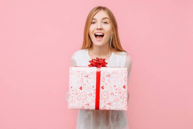 Şok genç kadın, onun elinde bir hediye kutusu ile beyaz bir elbise hediye ile mutlu