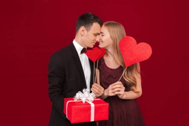 Mutlu bir çift, kağıt kalpler, kırmızı zemin üzerine tutan adam portresi sevenler gün