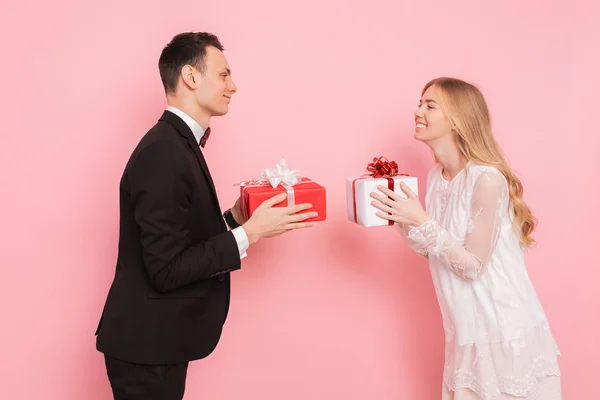 Casal Apaixonado Homem Mulher Dão Presentes Outro Fundo Rosa Dia — Fotografia de Stock