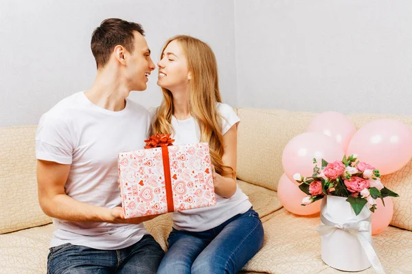Couple Love Man Gives Gift Woman Sits Home Sofa — Stock Photo, Image