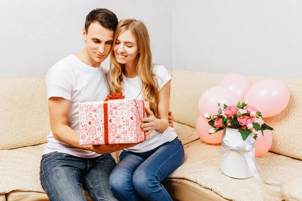 Couple Love Man Gives Gift Woman Sits Home Sofa — Stock Photo, Image