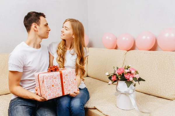 Couple Love Man Gives Gift Woman Sits Home Sofa — Stock Photo, Image