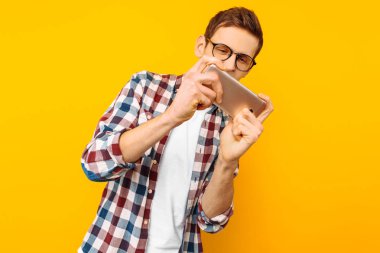 Stüdyo, öğrenci telefon ile sarı bir arka plan üzerinde telefon oyun adam